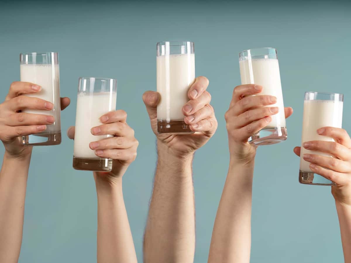 Fünf Hände halten jeweils ein Glas Milch hoch. 